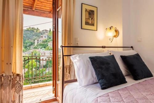 a bedroom with a bed and a balcony at Stemnitsa Stone Residence - Cosy Mountain Escape in Stemnitsa