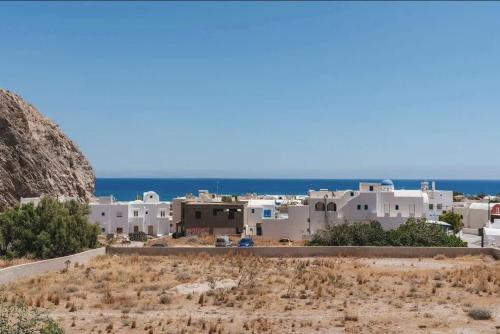 widok na wioskę z oceanem w tle w obiekcie Santorini Seaside Retreat - Flora's Summer Escape w mieście Perissa