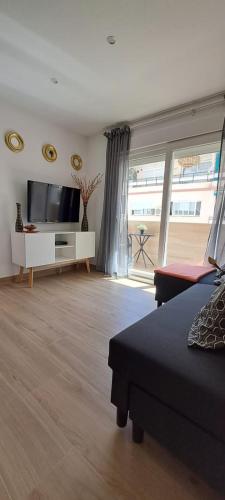 ein Wohnzimmer mit Flachbildfernseher und Couch in der Unterkunft Apartamento Centro Fuengirola in Fuengirola