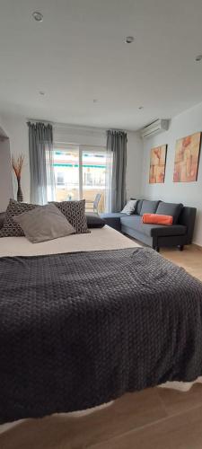 ein Schlafzimmer mit einem großen Bett und einer Couch in der Unterkunft Apartamento Centro Fuengirola in Fuengirola