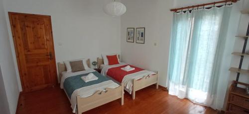 two twin beds in a room with a window at Skafidia Villa Yucca - Garden Haven Retreat in Skafidia