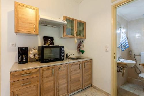 een keuken met een wastafel en een tv op een aanrecht bij Kalamata City Nest - Central & Cozy Hideout in Kalamata