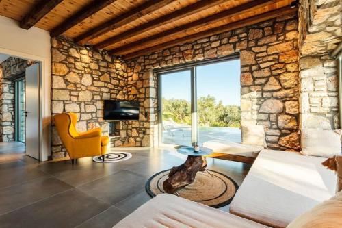 a living room with a stone wall at Gerakada Exclusive-Seaview Villa with Private Pool in Koroni