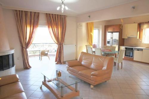 a living room with a couch and a table at Schinias Bright Spacious Maisonette-Panoramic View in Marathon