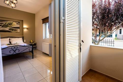 a bedroom with a bed and a large window at Filiatra Downtown Cozy Retreat - Homely Vibes in Filiatra