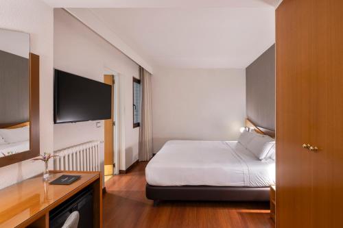 a hotel room with a bed and a television at Hotel de l'Isard in Andorra la Vella