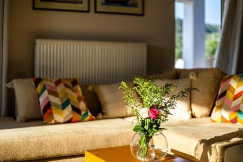 a living room with a couch and a vase with flowers on a table at Kitries Summer Getaway - Eden Comfy Suite in Kitriaí