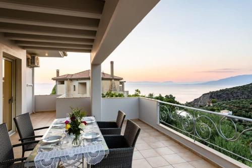 a patio with a table and chairs on a balcony at Kitries Summer Getaway - Eden Comfy Suite in Kitriaí