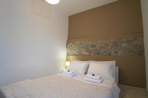 1 dormitorio con 1 cama con 2 toallas en Vilaeti Havgas Getaway - Cretan Cozy Home, en Agios Konstantinos