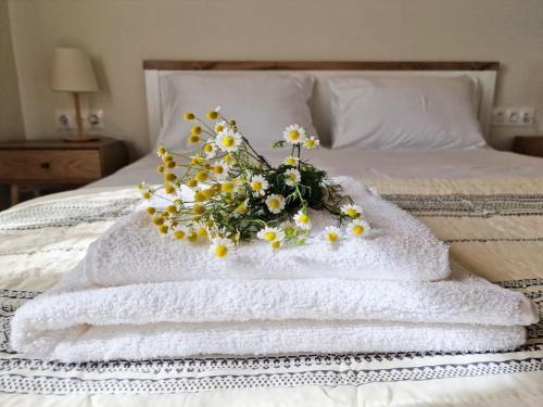 a bouquet of flowers sitting on top of a bed at Cozy Owl's Studio Home in Pýrgos