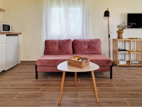 a living room with a red couch and a table at Cozy Owl's Studio Home in Pýrgos