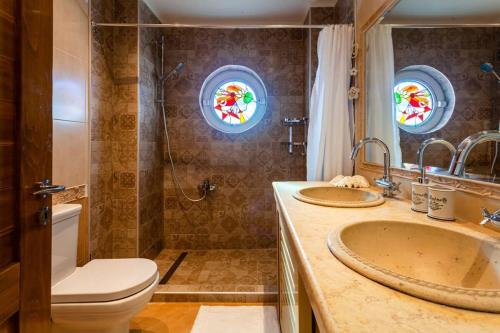 a bathroom with a toilet and a sink and a shower at Sunset Paradise - Verga's Utimate Seaview Getaway in Mírton