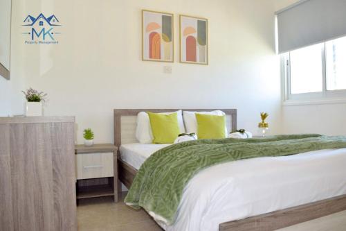 1 Schlafzimmer mit 2 Betten, einem Tisch und einem Fenster in der Unterkunft SeaWitch Apartment in Larnaka