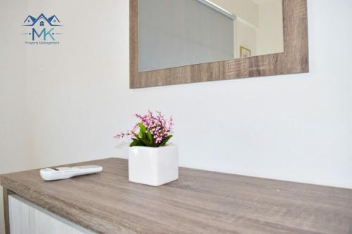 eine Badezimmertheke mit einem Spiegel und Blumen darauf in der Unterkunft SeaWitch Apartment in Larnaka