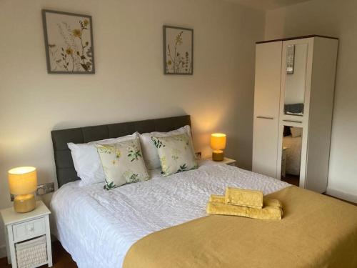 Park Cottage - Cosy 1 bedroom في Spinney Hill: غرفة نوم بها سرير مع مصباحين
