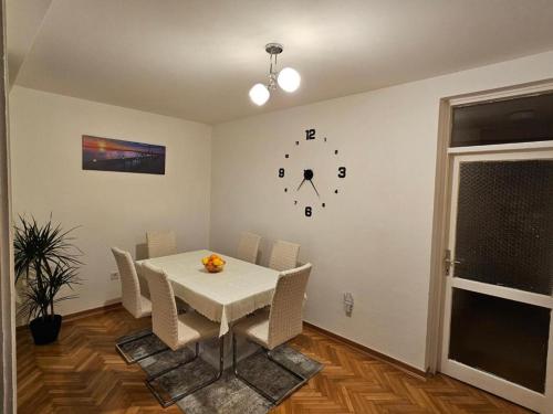 un comedor con una mesa y un reloj en la pared en Apartment Lea, en Kotor