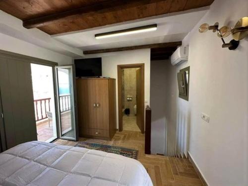 1 dormitorio con cama blanca y balcón en Ligaria Stone Maisonette Gem in Folegandros Heart, en Áno Meriá