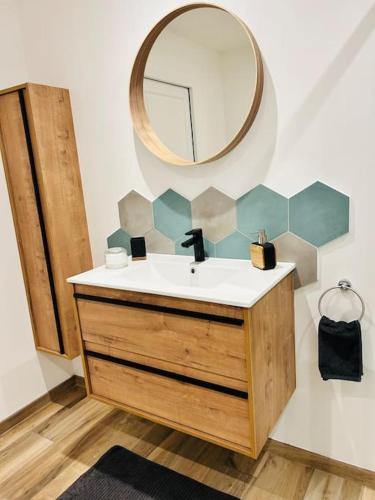 une salle de bain avec un lavabo et un miroir dans l'établissement Maison au calme, à la campagne, à Fontenay-le-Marmion