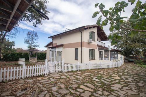 a white house with a white picket fence at Kozareva Guest House 2 Козаревата Къща За Гости 2 in Dobrogled