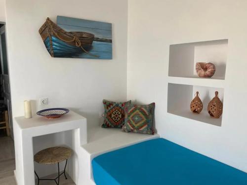 una habitación con un banco con jarrones en la pared en Folegandros Enchanting Cycladic Home Sunset Views en Áno Meriá