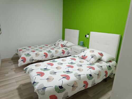 2 camas en una habitación con paredes verdes en Apartamento confort I en La Seu d'Urgell