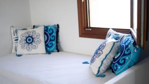 tres almohadas sentadas en una cornisa en una habitación en Folegandros Serenity - Livadaki Summer Hideaway en Áno Meriá