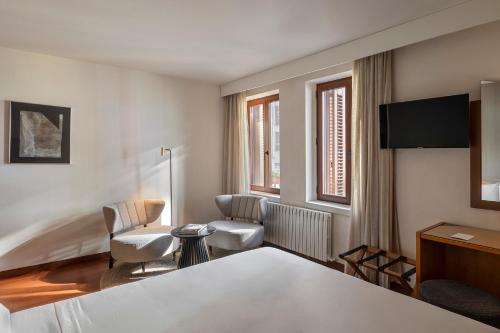 um quarto de hotel com uma cama, uma mesa e cadeiras em Hotel de l'Isard em Andorra-a-Velha