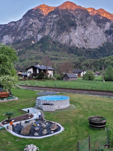 a backyard with a swimming pool and a mountain at Ferienwohnung Stricker in Obertraun