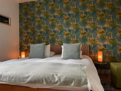 1 dormitorio con 1 cama y papel pintado con motivos florales en La Majolique, en Namur