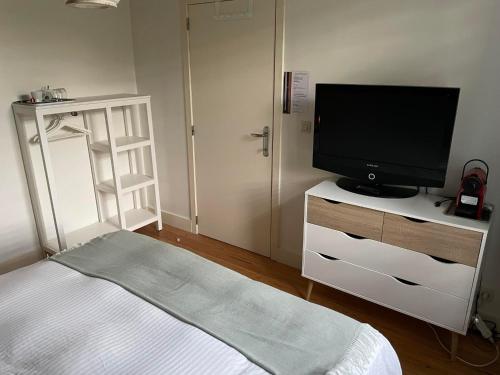 a bedroom with a bed and a television on a dresser at La Majolique in Namur