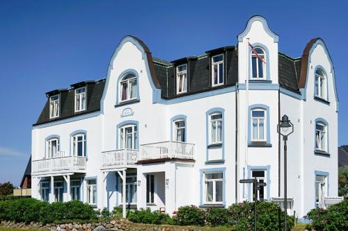 un gran edificio blanco con techo negro en Hotel Villa Klasen, en Wenningstedt
