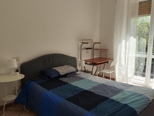 a bedroom with a bed and a table and a window at Casa Coiri in Cairo Montenotte