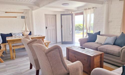 a living room with a couch and chairs and a table at Kleine Brakke - Coastal Cottage in Klein-Brakrivier