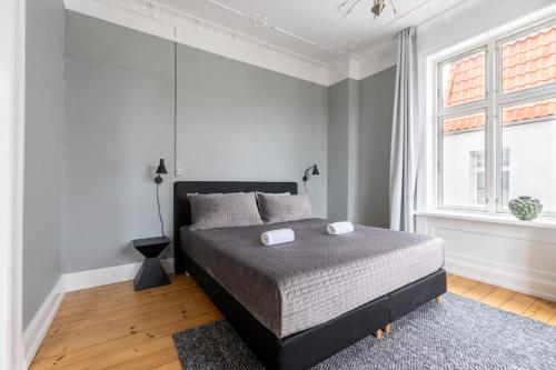 a bedroom with a bed and a large window at Perfect Holiday Homes Near Amager Beach in Copenhagen