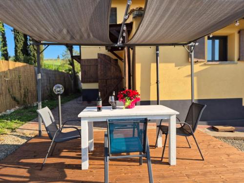 a white table and chairs under an umbrella at CASA ORNETO in Poggibonsi