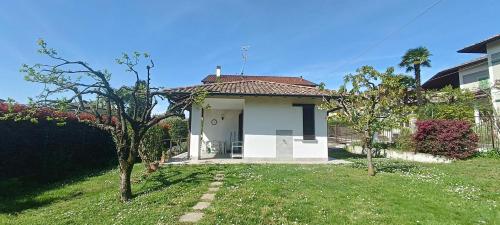 a small white house with a grass yard at La Casa di Rina in Angera