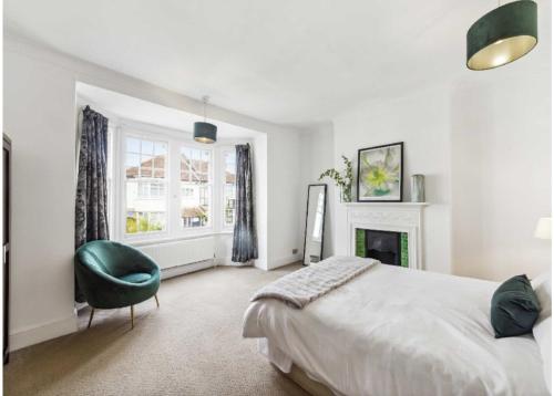 a bedroom with a large bed and a green chair at Arragon in Streatham Vale