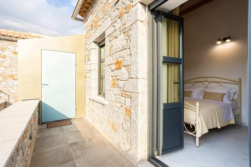 a bedroom with a bed on a balcony at Mani Stone Built Home A breath Away to the Sea in Stoupa