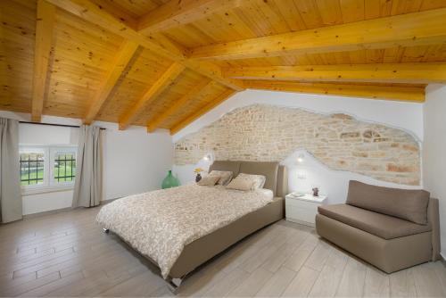 1 dormitorio con 1 cama grande y 1 silla en Villa Bilinke by IstriaLux, en Štokovci