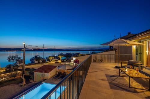 a balcony of a house with a view of the water at Villa BEACHFRONT in Klimno