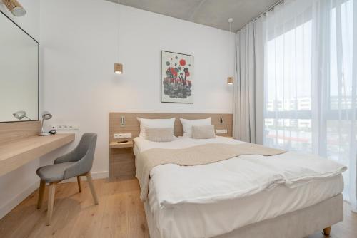 En eller flere senger på et rom på Beautiful White - Beige Apartment with Balcony in Wrocław