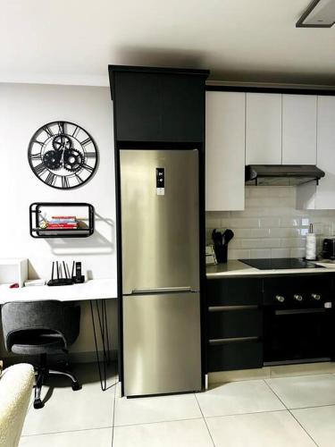 uma cozinha com um frigorífico de aço inoxidável em Aries self-catering Unit em Centurion