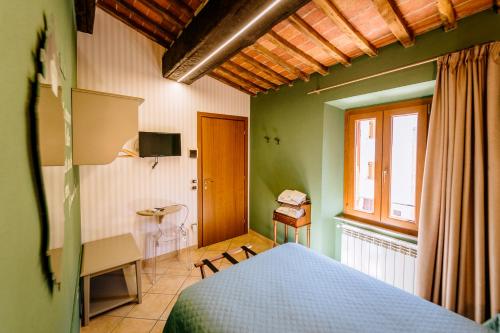 1 dormitorio con cama, mesa y ventana en B&B Da Nada Locanda Toscana en Roccatederighi