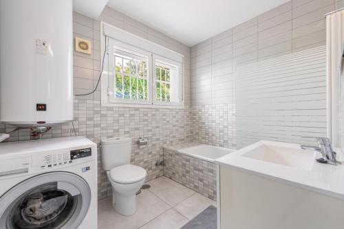 łazienka z toaletą, umywalką i pralką w obiekcie Sol y Paz 3, Nice apartment with great location w Marbelli