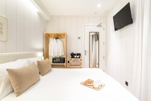 a white bedroom with a white bed and a dresser at Casa Bella Gracia by Aspasios in Barcelona