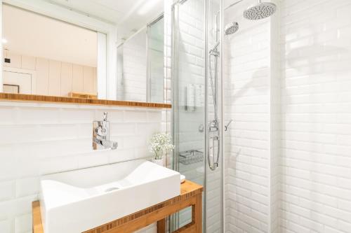 a white bathroom with a sink and a shower at Casa Bella Gracia by Aspasios in Barcelona