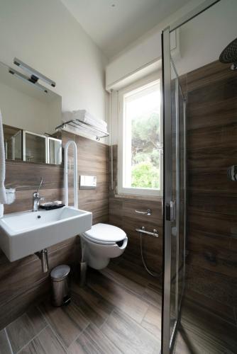 a bathroom with a sink and a toilet and a window at Hotel Maarea in Milano Marittima