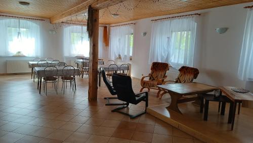 a dining room with tables and chairs and windows at Agroturystyka STANICA in Nowy Gierałtów