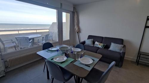 un salon avec une table et un canapé dans l'établissement Une terrasse sur la Mer, à Berck-sur-Mer
