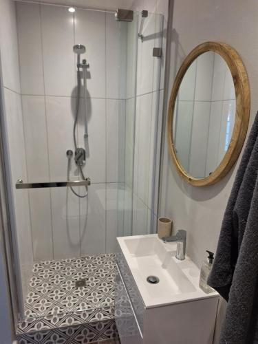 uma casa de banho com um chuveiro, um lavatório e um espelho. em 4 Periwinkle Place na Cidade do Cabo